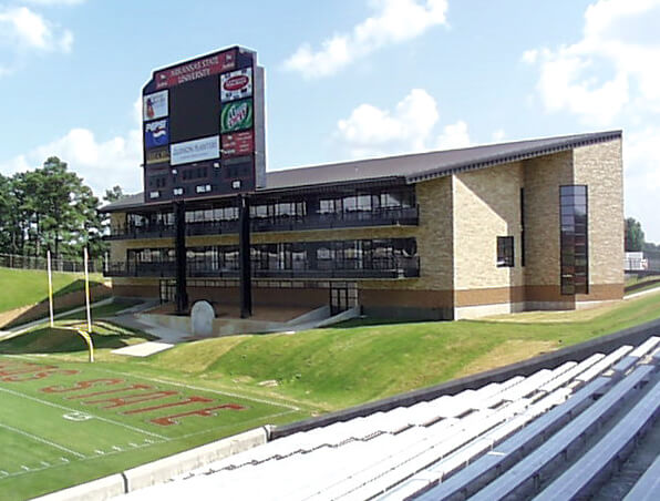 Renovated fieldhouse beside stadium scoreboard and stands