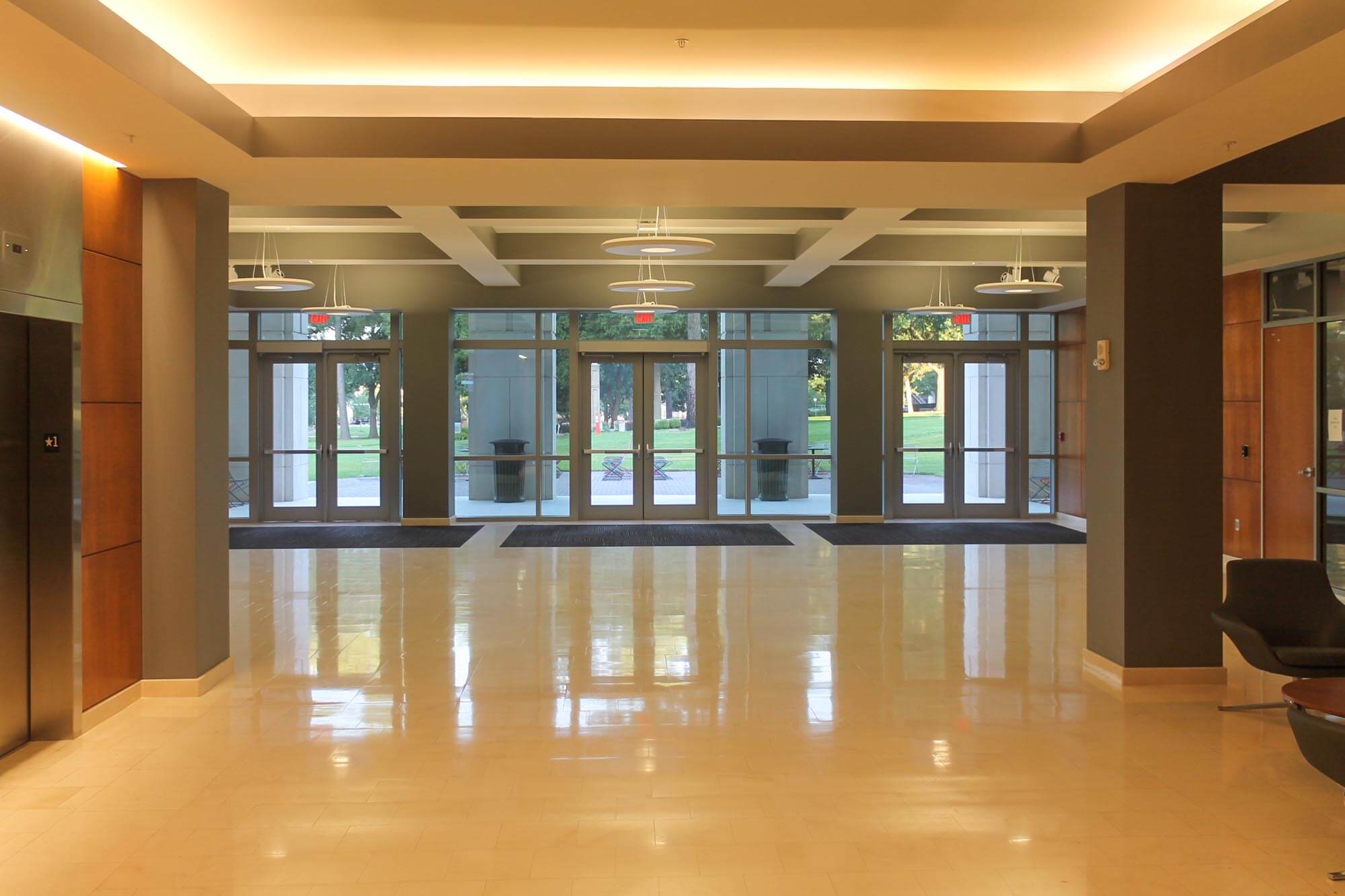 Interior lobby with polished floor and glass entrance doors framed by high transom windows