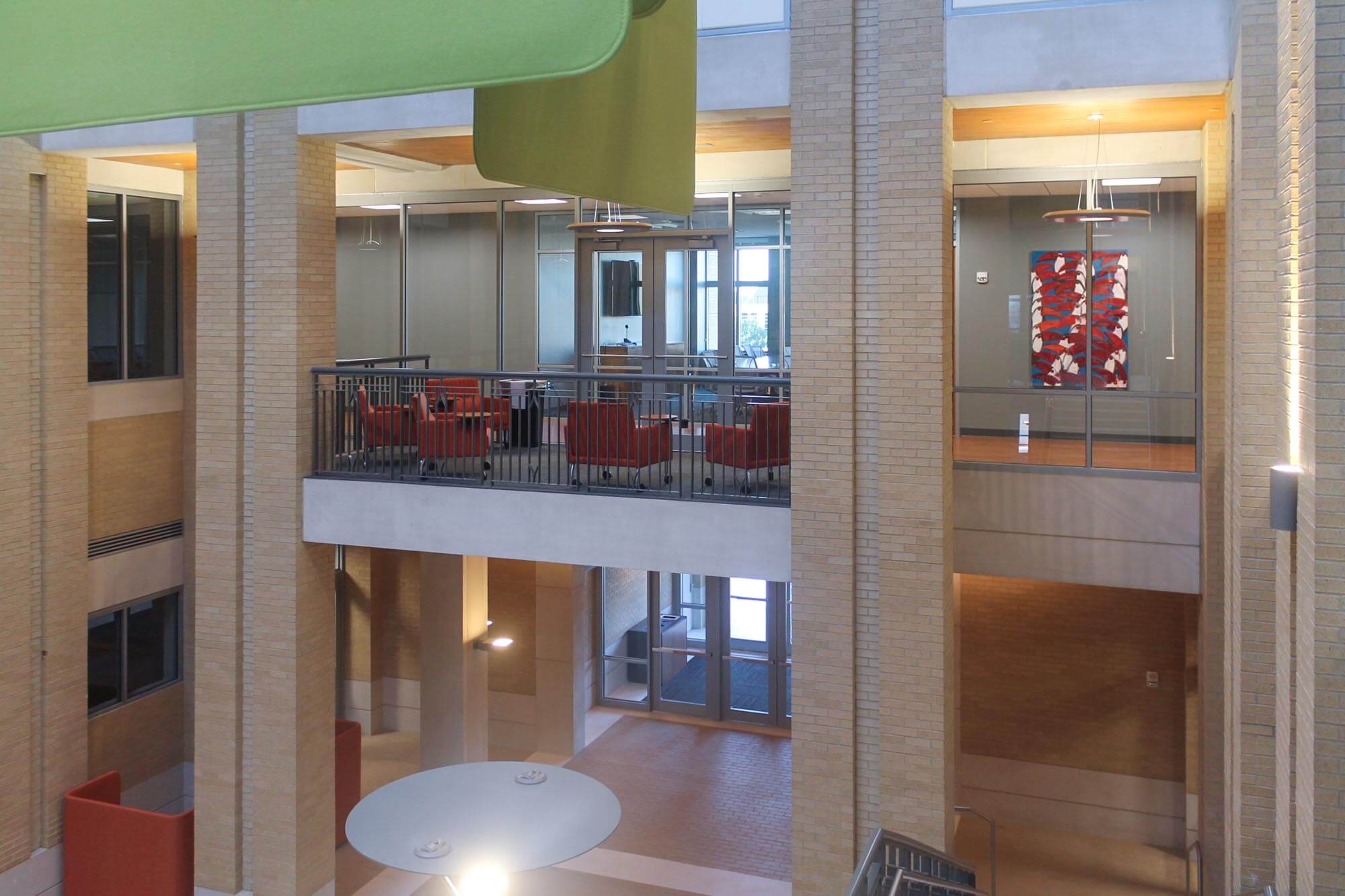 Second-floor lounge with red chairs and artwork displayed on the wall