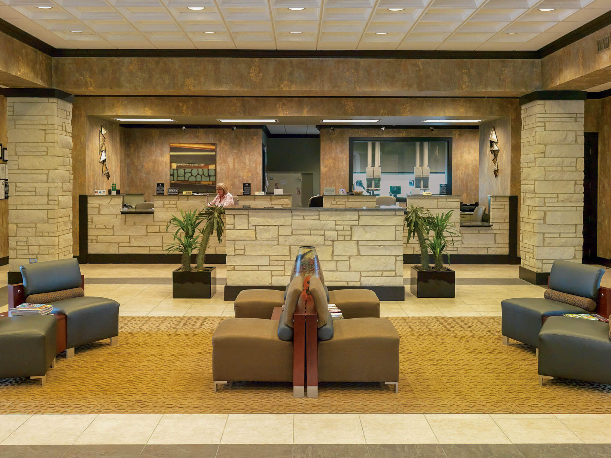 Interior shot of Focus Bank lobby, featuring a stone-accented teller counter, warm-toned walls, and decorative columns