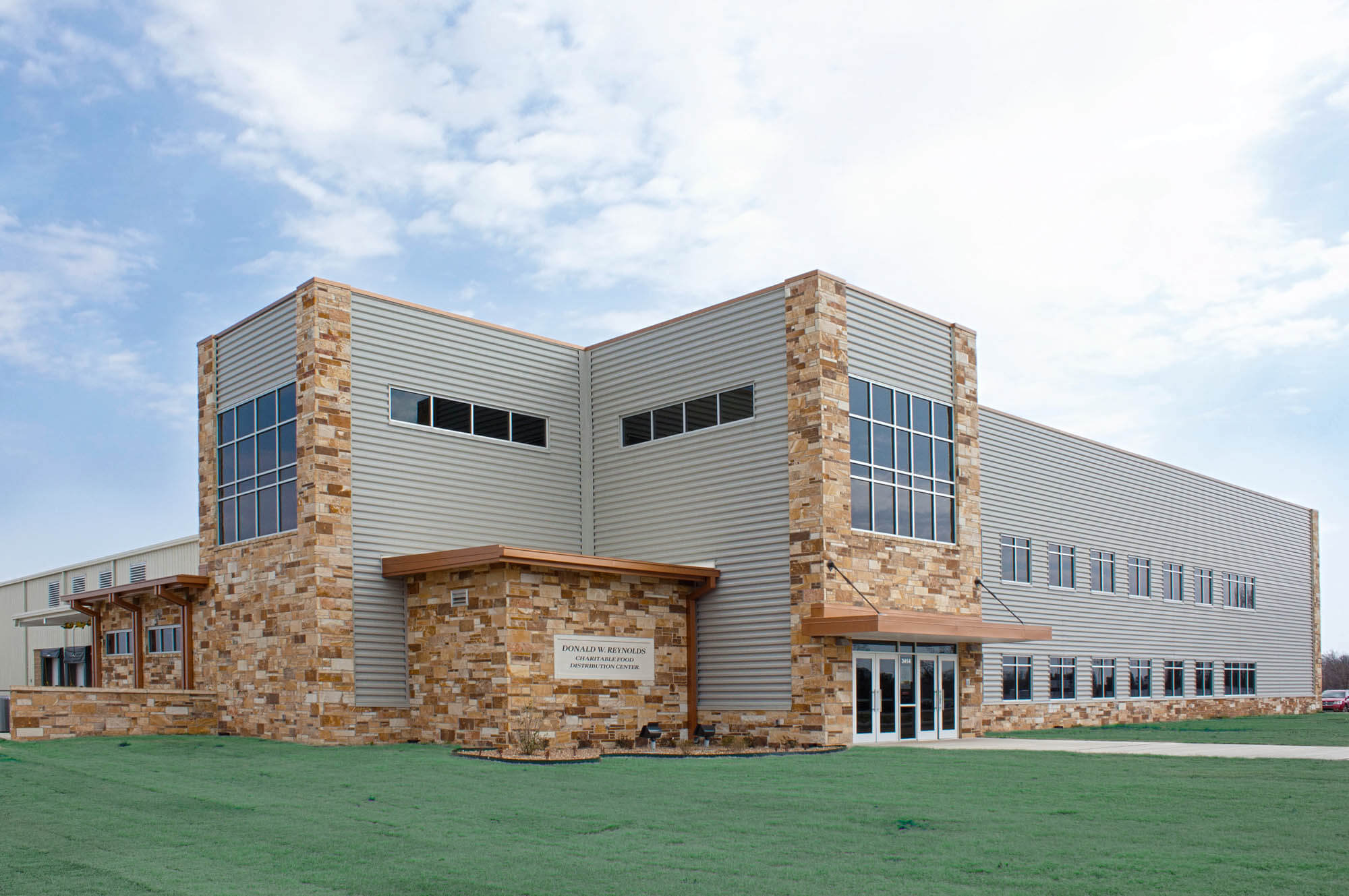 Exterior shot taken from an oblique three-quarter view, showcasing the primary façade and a portion of the side elevation to emphasize massing, materiality, and fenestration