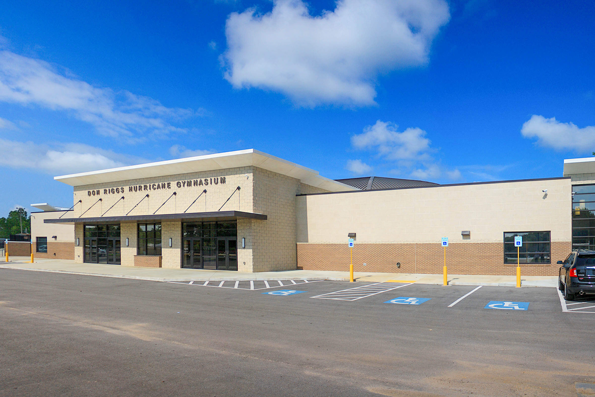 Angled exterior view with canopy and accessible parking at the renovated gym