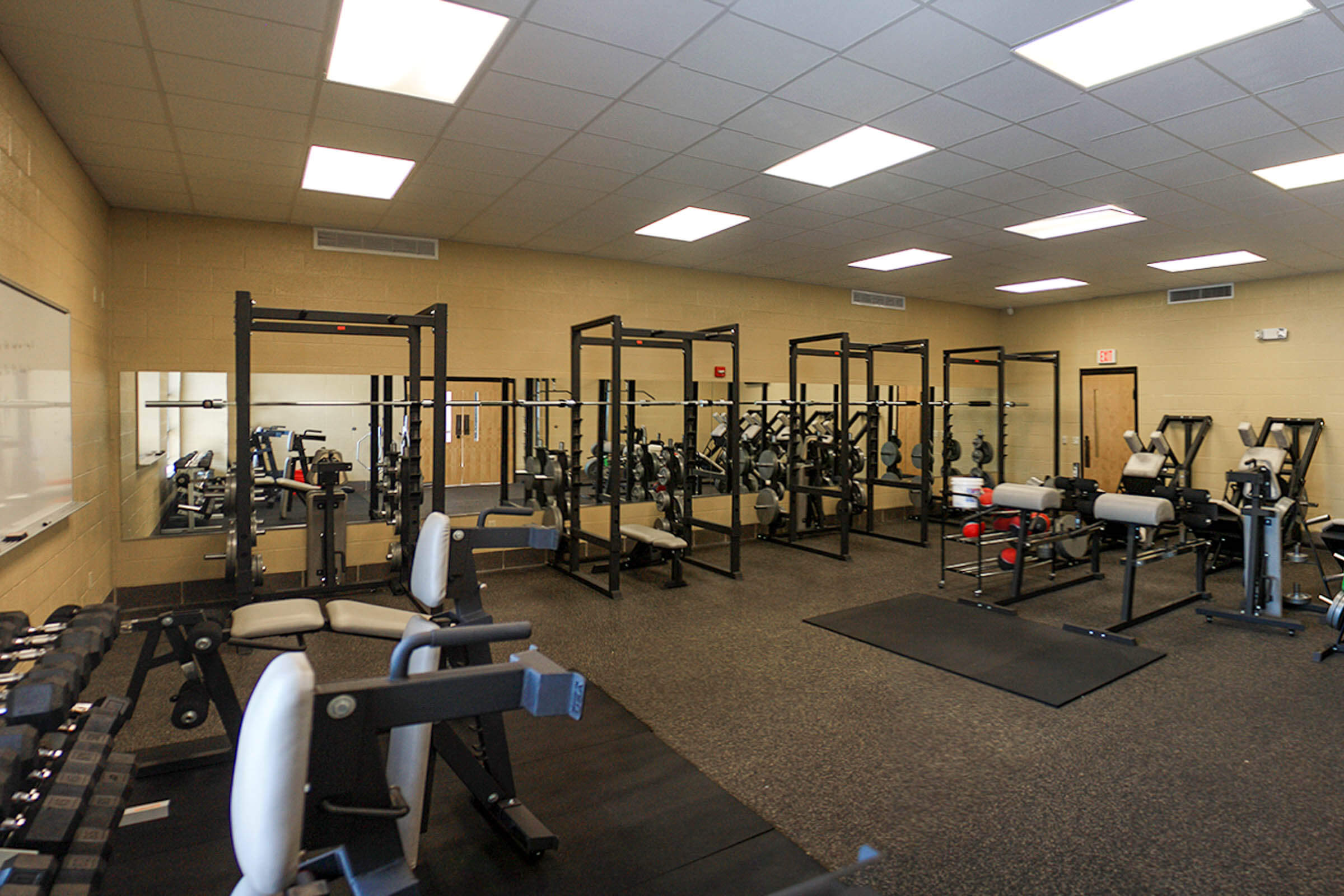 Weight room interior with squat racks, benches and open layout