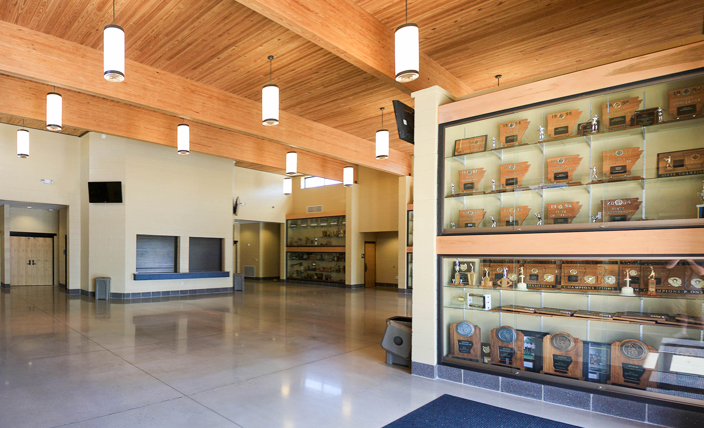 Spacious lobby with trophy case, concession stand, polished concrete floor and wood beam ceiling