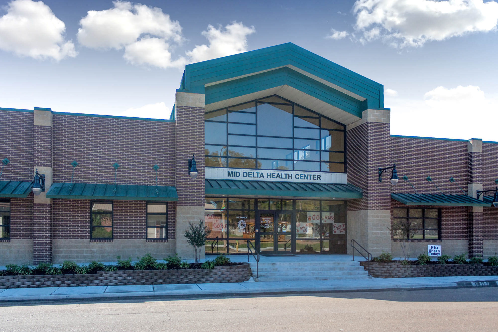Symmetrical front view emphasizing the gabled canopy and Mid‑Delta Health Center sign