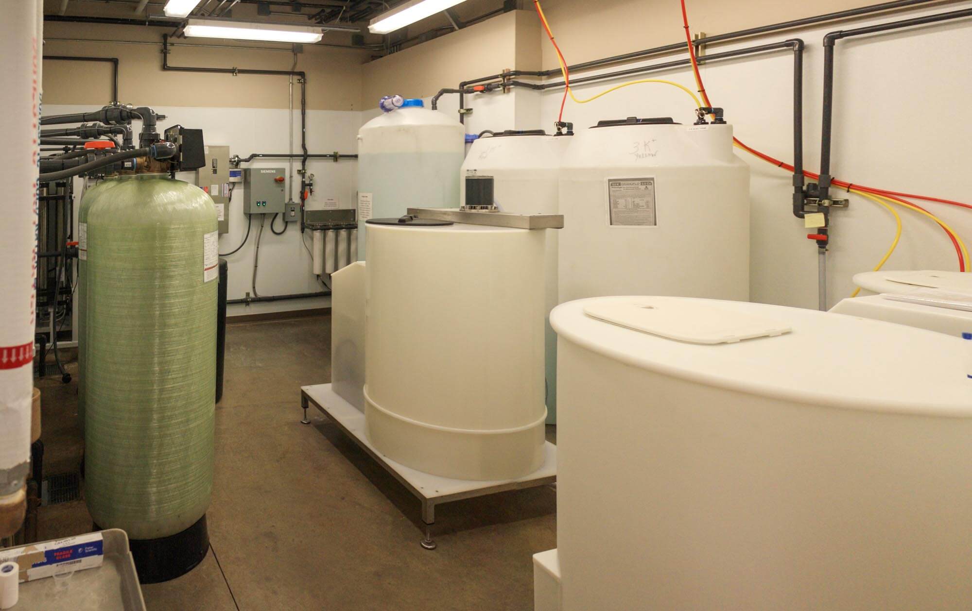 Mechanical room containing water treatment tanks and piping equipment