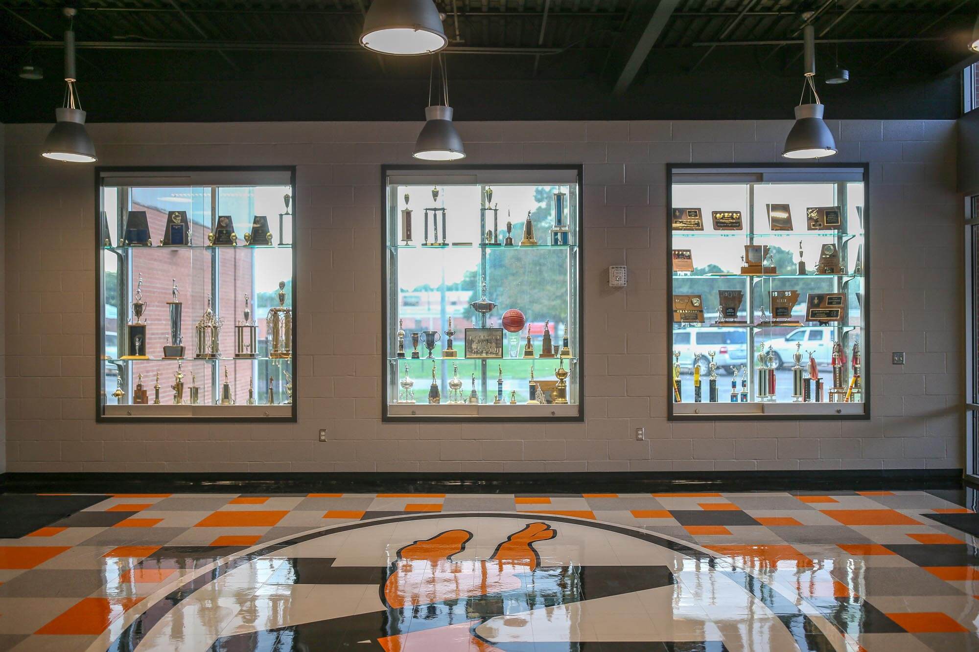 Interior view with large glass windows used as trophy cases, orange and gray floor pattern and round greyhound graphic