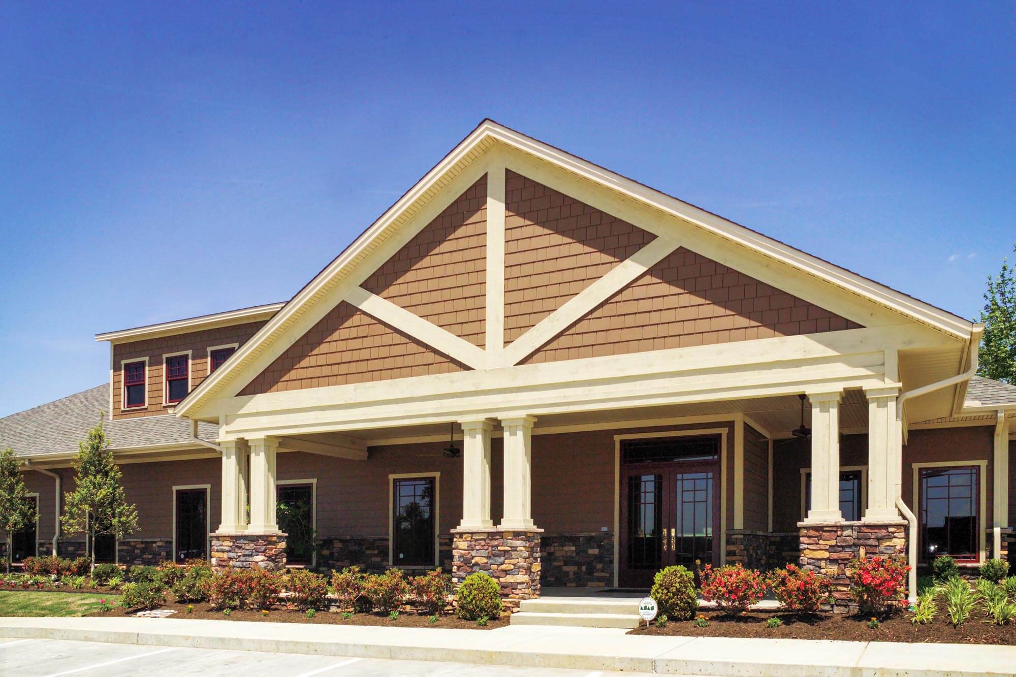 Front exterior of Parkey-Davis Dental Clinic with craftsman-style architecture, stone column bases, and landscaped entrance