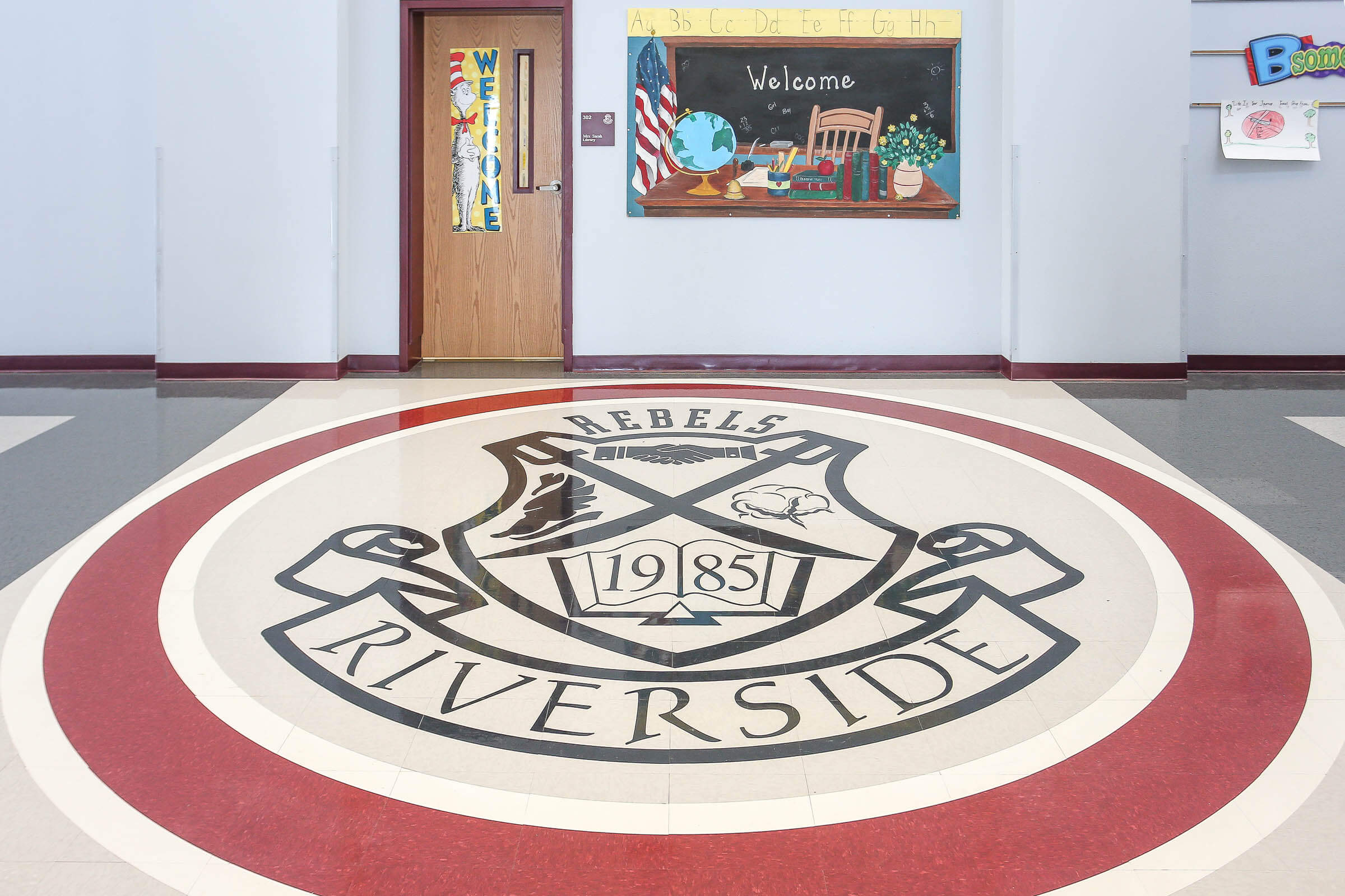 Lobby floor medallion bearing the 'Riverside Rebels 1985' crest encircled by red and white rings