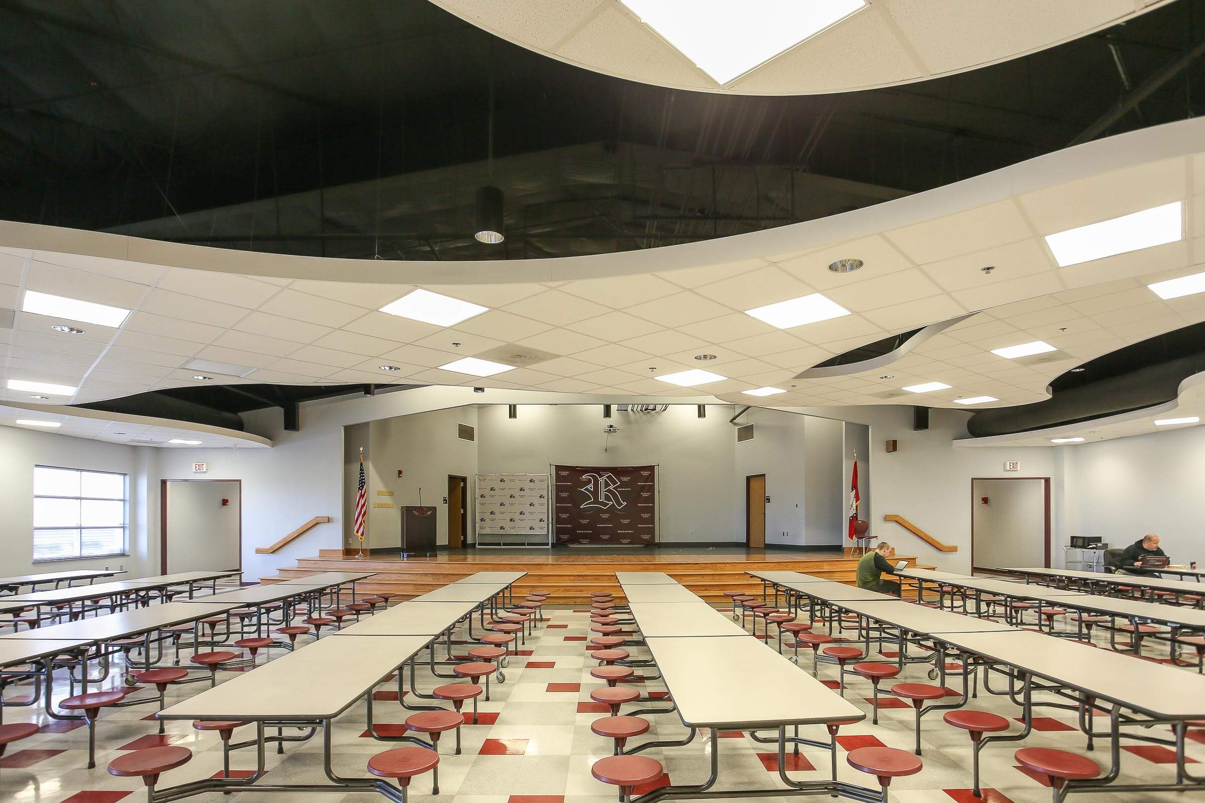Cafeteria view emphasising the stage and wavy ceiling elements