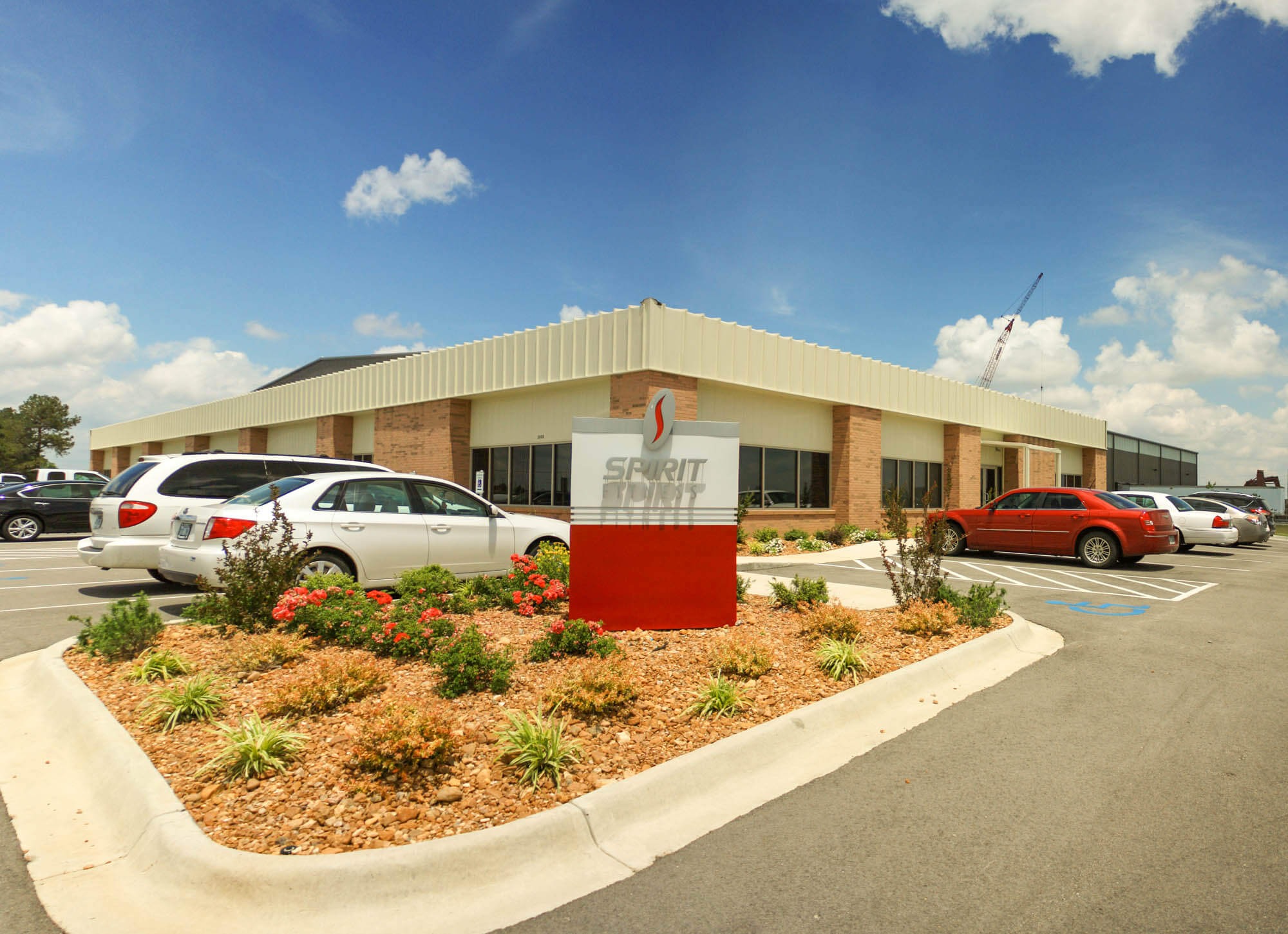 Exterior view of Spirit Manufacturing Facility showing a long metal-clad building with brick columns