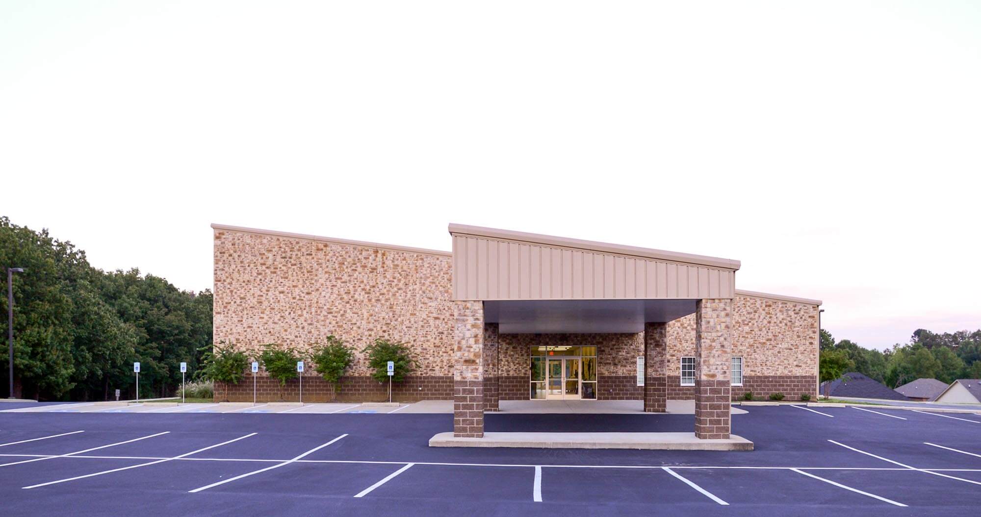 Front view of Stoneridge Church of Christ with stone facade, covered entrance, and parking lot