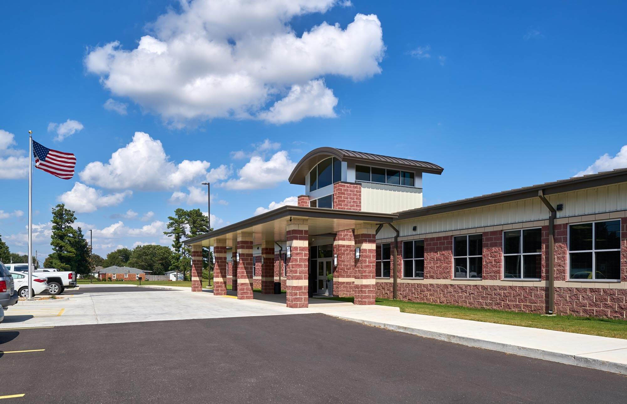 Front view of Trumann Elementary School with red brick entrance, covered walkway, and American flag