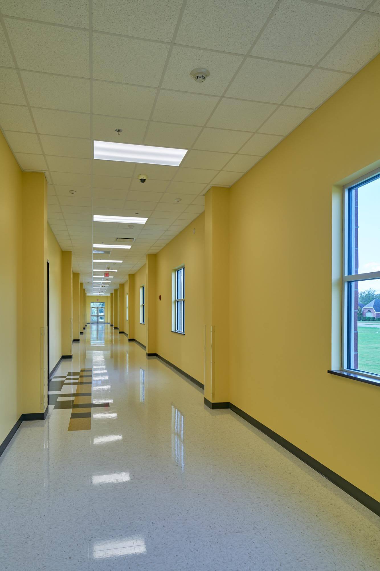 Interior hallway of Trumann Elementary with yellow walls, tiled floor, and windows along the side