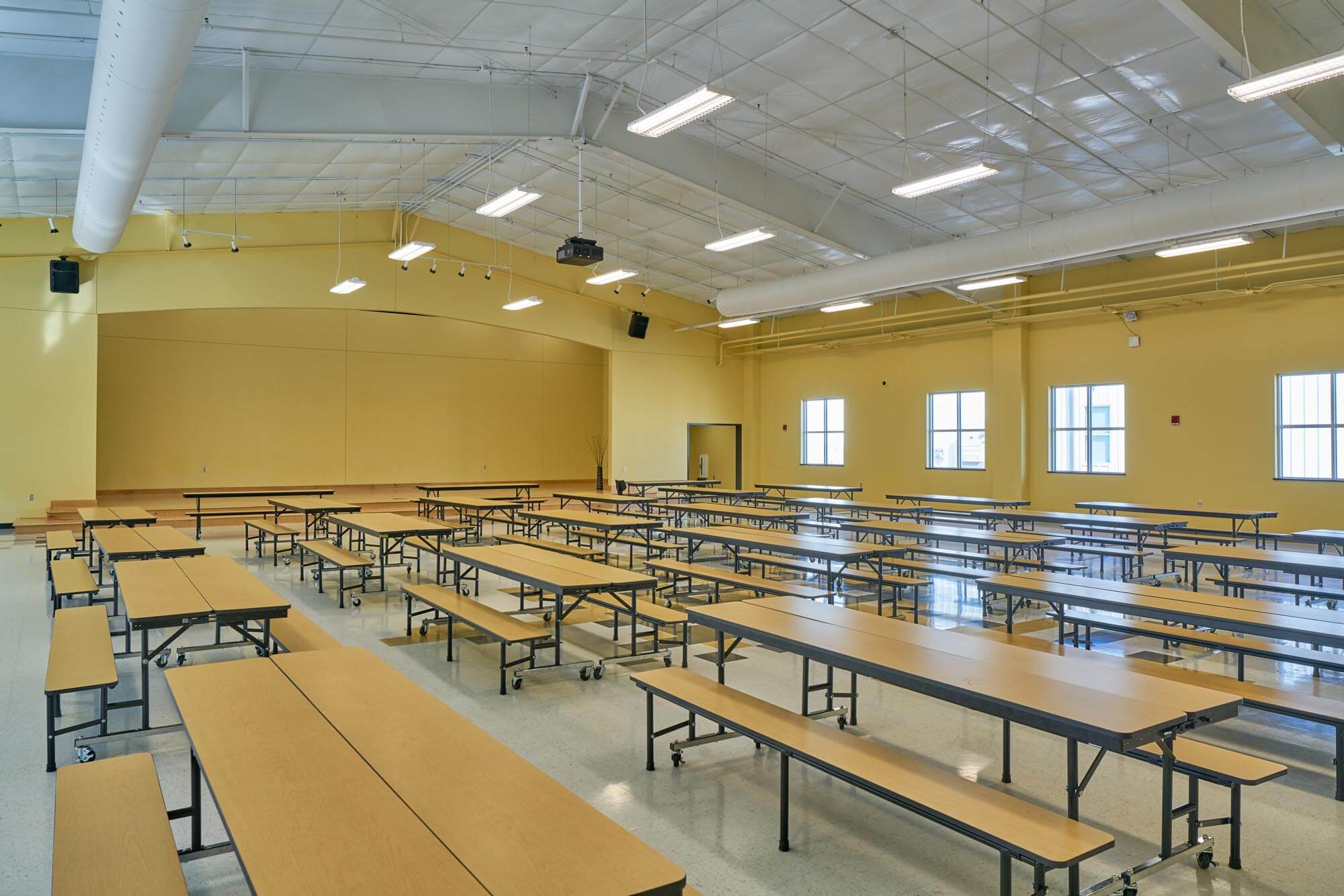 School cafeteria with long folding tables and benches on wheels