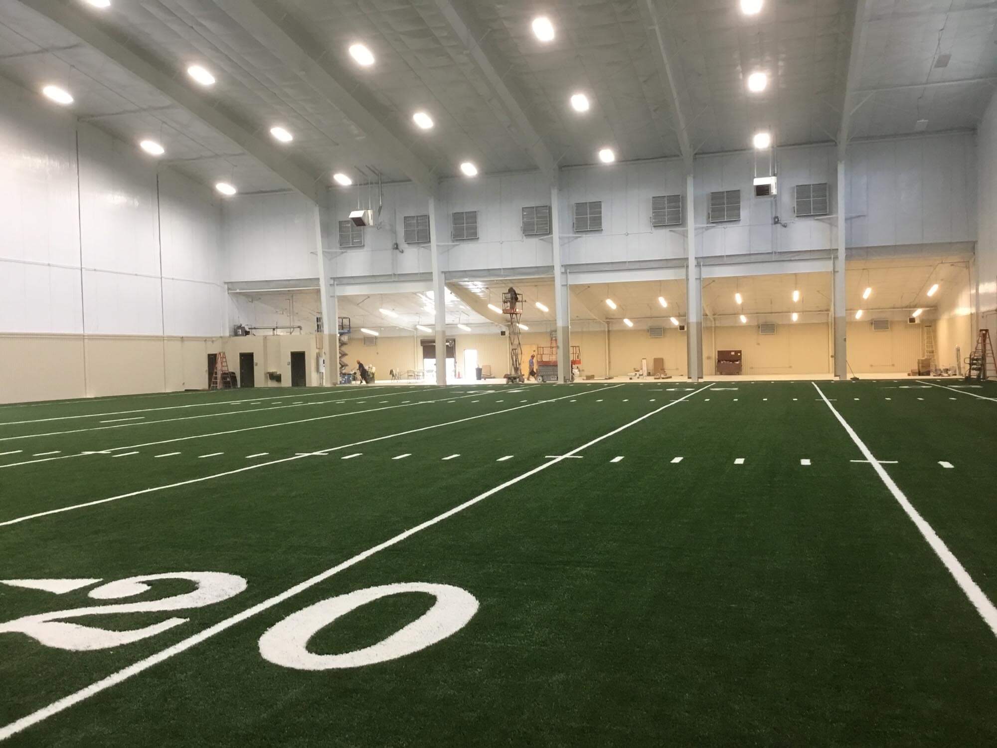 Alternate view of the indoor practice facility showing overhead mechanical equipment and turf floor