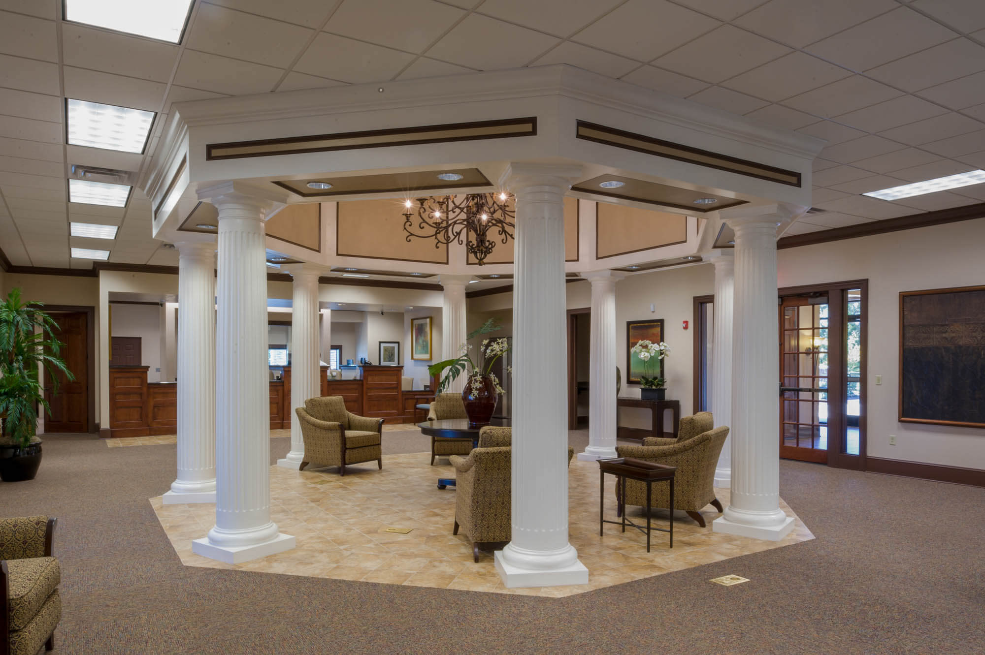 Central gazebo-like seating area with white columns, chandelier and surrounding offices