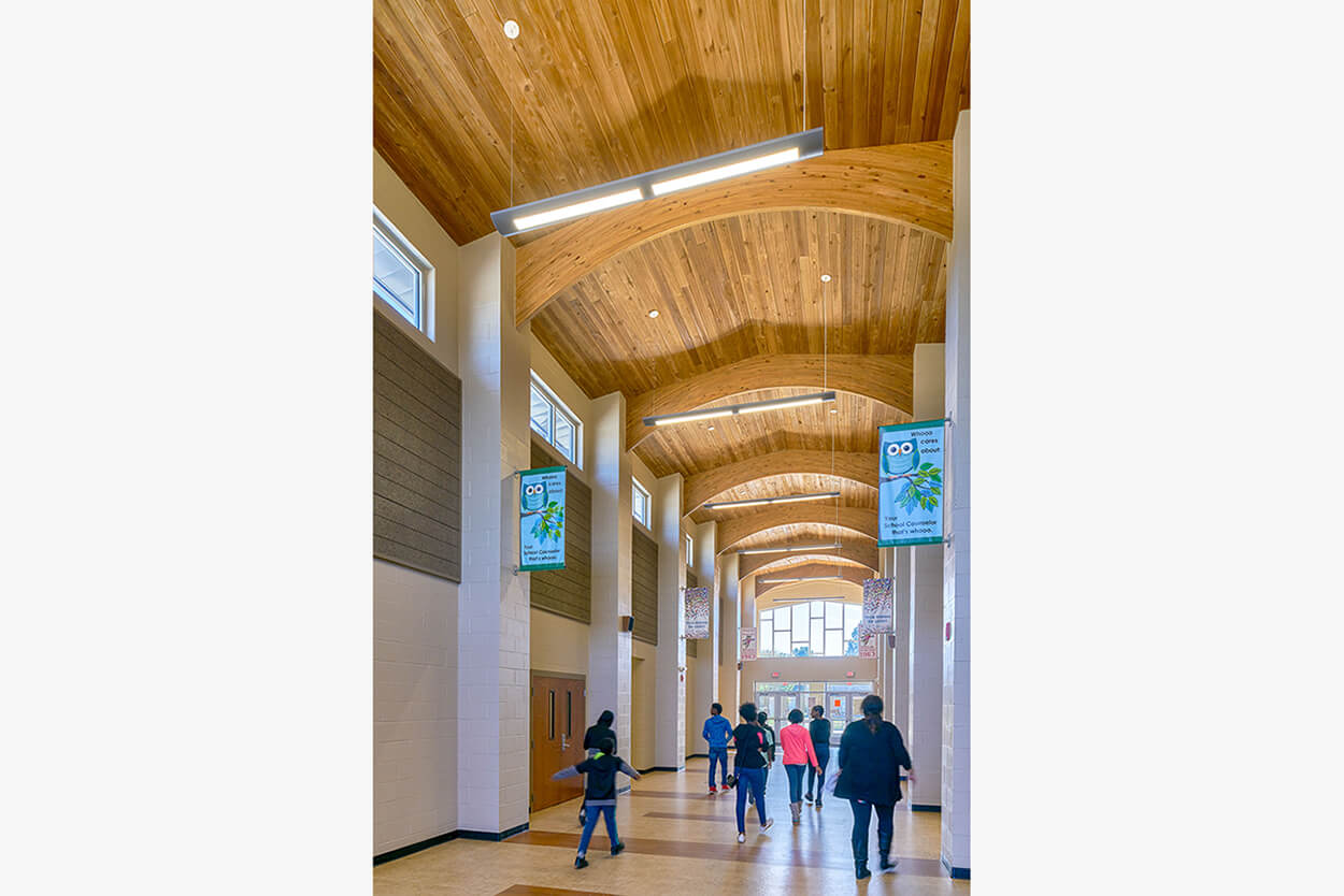 Hallway with students and colorful owl banners hanging from the ceiling