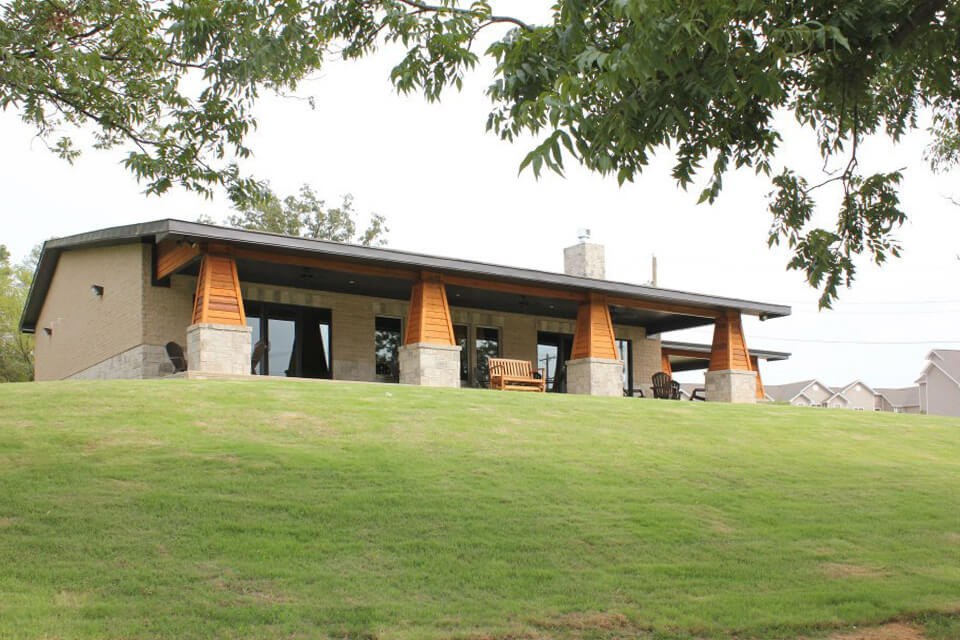 Exterior of WolfLife Campus Ministry Building with stone columns, wood accents, and covered porch seating
